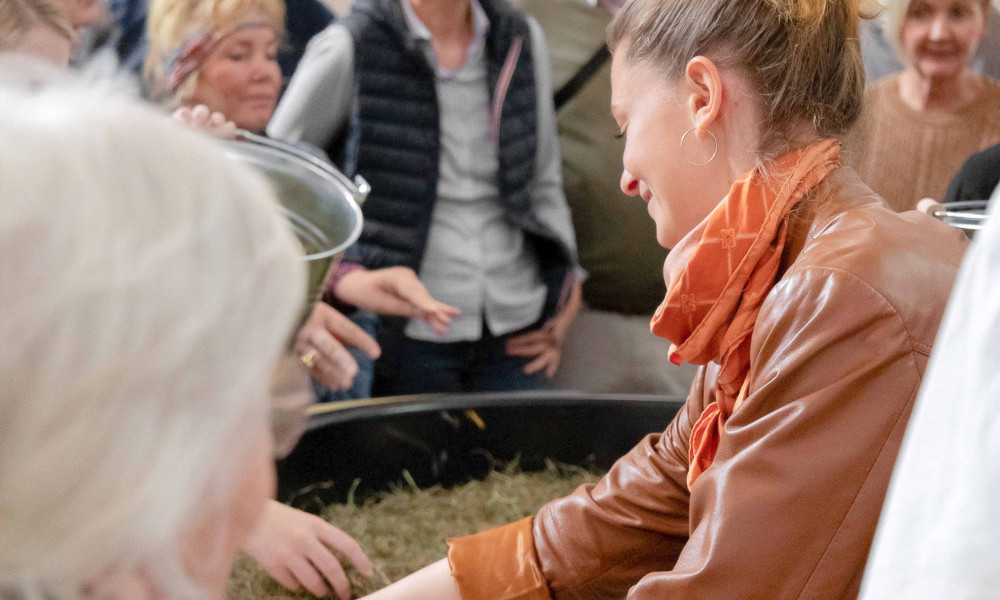 Personen schauen sich interessiert das Substrat eines Kokons an